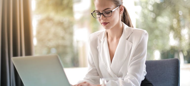 Žena kuca na laptopu i pravi prezentaciju svog brenda što je jedan od koraka ka snažnom online nastupu za svako poslovanje.